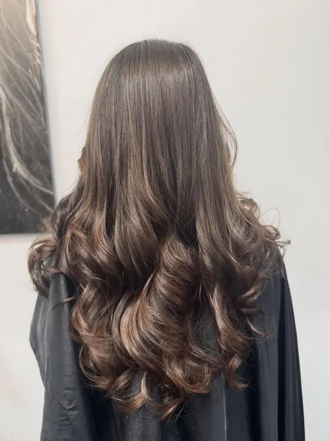 Long brunette hair with caramel balayage curls
